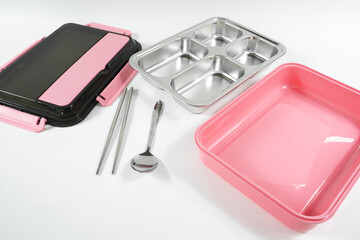 Plastic and stainless lunch box, which is black and pink in color. n white background, food...