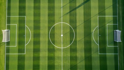 An aerial view showcases a vibrant green soccer field with white markings
