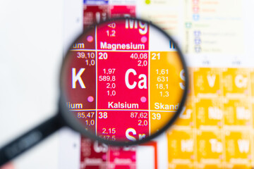 Close-up of Calcium (Ca) element appears enlarged under a magnifying glass with detailed atomic...