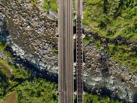 Aerial Photo of Railway Bridge Crossing River in Rural Area – Scenic Infrastructure for Transportation, Travel, Documentary, etc.
