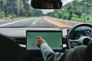 Hand using touchscreen navigation in electric car