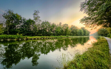 A serene and tranquil river scene beautifully showcasing vibrant foliage and peaceful water reflections during dawn