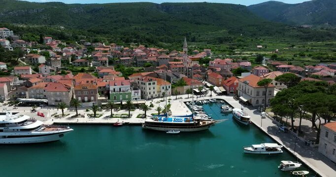 Boats And Yachts Docked In Coastal Town Of Jelsa On Hvar Island In Croatia. aerial pullback shot