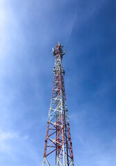 single telecommunication tower with bright blue sky, low-angle shot
