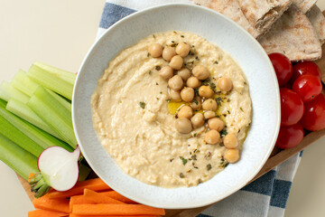 Fresh hummus in a bowl with pita, celery and carrots. Chickpea dishes. 