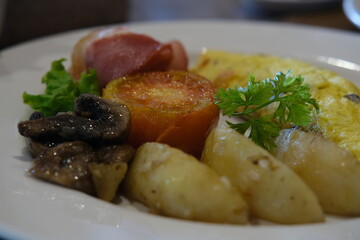 Classic Breakfast Plate with Omelette, Bacon, Tomato, and Potatoes