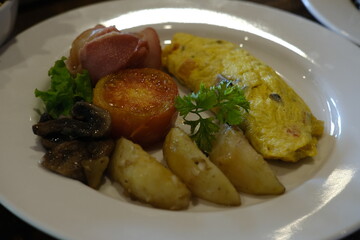 Classic Breakfast Plate with Omelette, Bacon, Tomato, and Potatoes