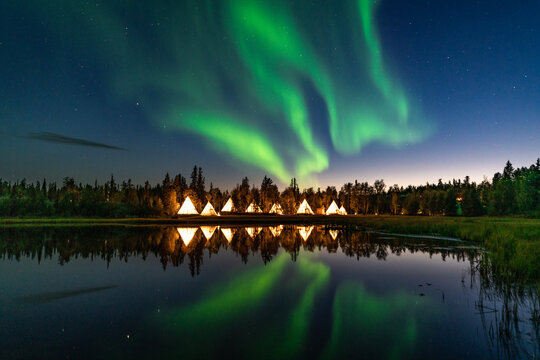 Northern Lights, Aurora Borealis over Teepee and Forest, Reflection over the Lake, Yellowknife, Northwest Territories, Canada
