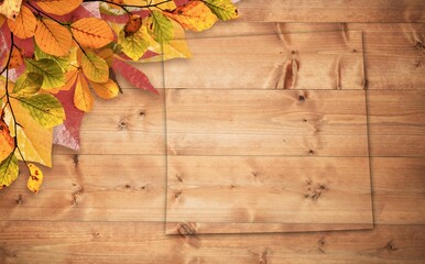 Glass on wooden table with autumn leaves