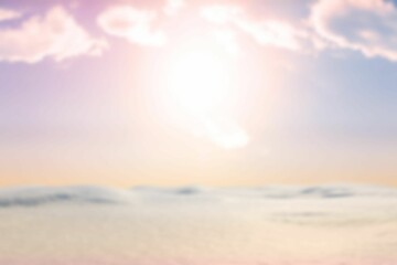 Glowing sun is casting warm pastel light over calm water or dunes in flat design