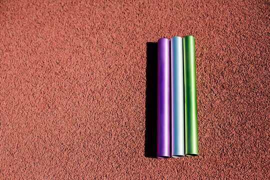 Three relay batons on the ground