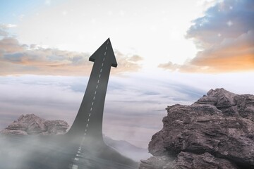 Road arrow rising from rocky plateau is cutting through swirling mist under sunrise sky, copy space