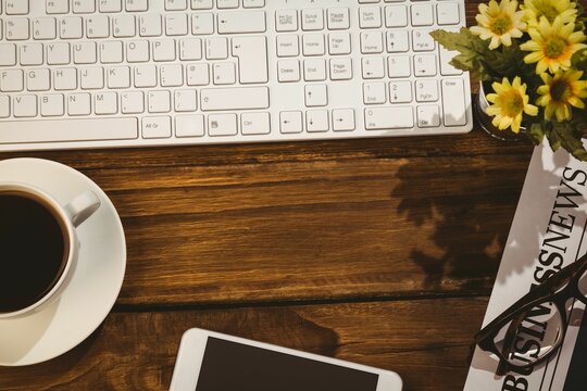 Fototapeta Overhead view of keyboard with coffee cup
