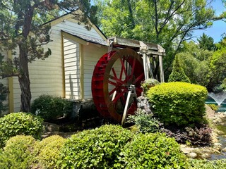 Charming water wheel on the side of an old farmhouse — nostalgic and timeless, evoking the simplicity and ingenuity of rural life. © Curiosity Photos