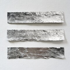 Three strips of textured, metallic material