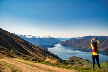 Rear view of hiking tourist  making a heart symbol at the top of Roys Peak Wanaka New Zealand