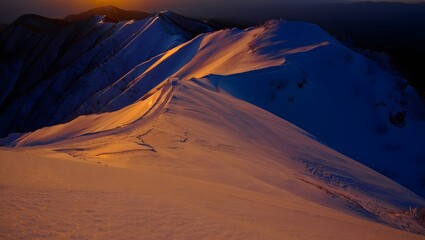 snowy mountain ridge at sunset.