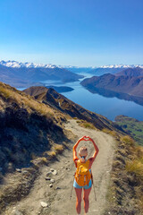 Rear view of hiking tourist  making a heart symbol at the top of Roys Peak Wanaka New Zealand