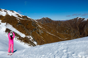 Rear view of hiking tourist  making a heart symbol at the top of Roys Peak Wanaka New Zealand