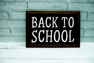 Back to school text with blackboard on white brick backgroun