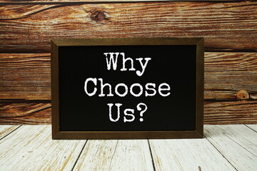 Why choose us? text written on chalkboard standing on wooden background