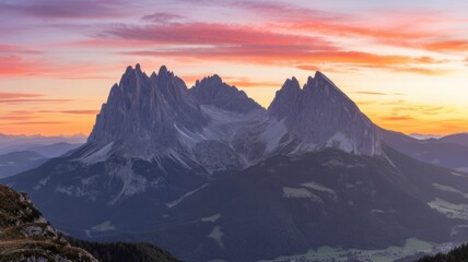 Spectacular mountain peaks bathed in the warm hues of a stunning sunset, creating a serene and majestic landscape