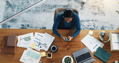 Above, woman or phone in office for social media marketing, research, engagement or trends. Paperwork, planning and content strategist with mobile app for creative project or online platform at desk