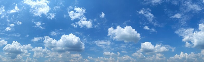 Naklejka premium Sunny blue sky dotted with puffy white clouds