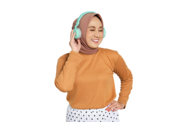 Muslim woman in hijab enjoying music with headphones while smiling isolated on transparent background