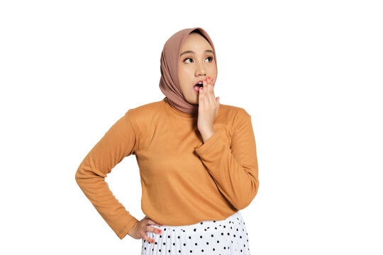Surprised young Muslim woman in hijab covering mouth with hand isolated on transparent background - Powered by Adobe