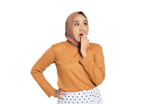 Surprised young Muslim woman in hijab covering mouth with hand isolated on transparent background