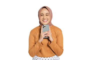 Happy young Muslim woman in hijab smiling while holding smartphone close to chest isolated on transparent background