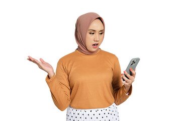 Shocked young Muslim woman in hijab looking at smartphone with confused expression isolated on...