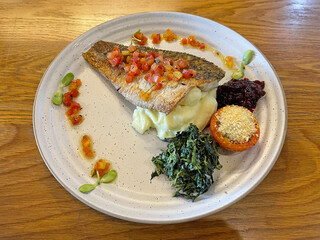 Grilled seabass steak served with spinach, berry jam, vegetables and mashed potatoes