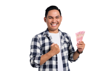 Happy young man in checkered shirt holding Indonesian rupiah money and celebrating success with clenched fist isolated on transparent background