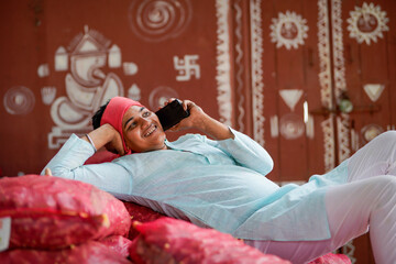 Happy indian farmer talking on smartphone