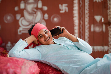 Happy indian farmer talking on smartphone