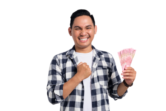 Happy young man in checkered shirt holding Indonesian rupiah money and celebrating success with clenched fist isolated on transparent background - Powered by Adobe