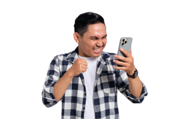 Excited young man in checkered shirt clenching fist while looking at smartphone screen with happy expression isolated on transparent background