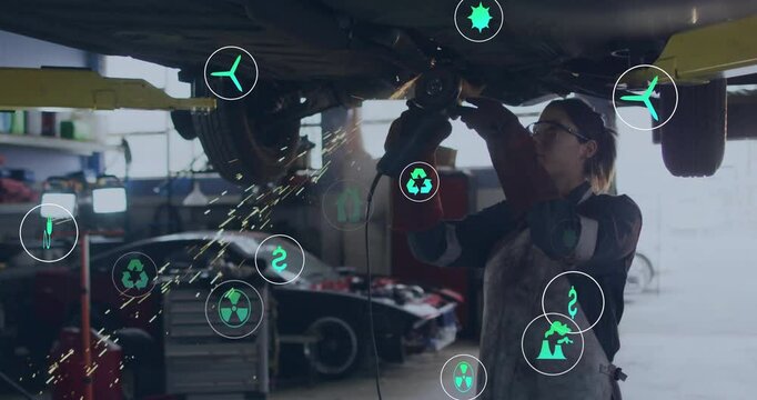 Auto mechanic switching grinder on, grinding underbody for repair while eco finance icons floating - Powered by Adobe