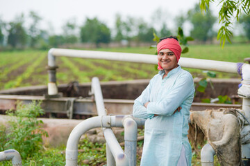 happy farmer with water pipe or water resources at agriculture field