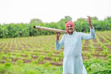 happy farmer with water pipe or water resources at agriculture field
