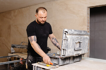 Construction worker taking hammer from toolbox during renovation works