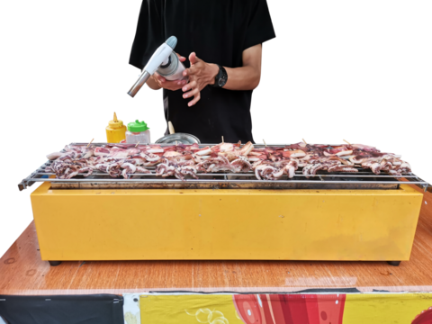 Street food vendor grilling squid satay with a blowtorch.
Midsection of man preparing food on barbecue grill. 

