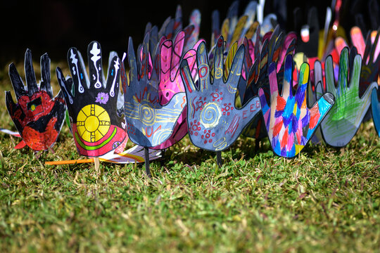 Paper hands decorated with Indigenous Australian messages - horizontal
