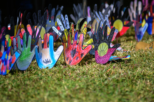 Paper hands decorated with Indigenous Australian messages - horizontal