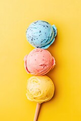 Three colorful ice cream scoops on a stick against a bright yellow background