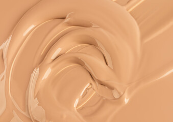 A background of liquid foundation powder in a natural tone. The delicate texture of the soft waves...
