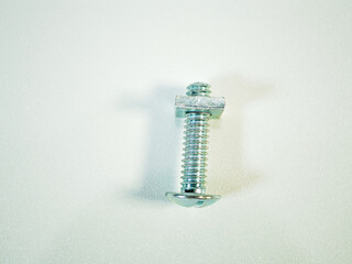 Shiny metal bolt and nut on a clean white surface, perfect for representing fasteners or...