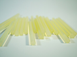 Gathering of solid, yellow glue sticks ready for art and craft projects or home repairs, lying on a...